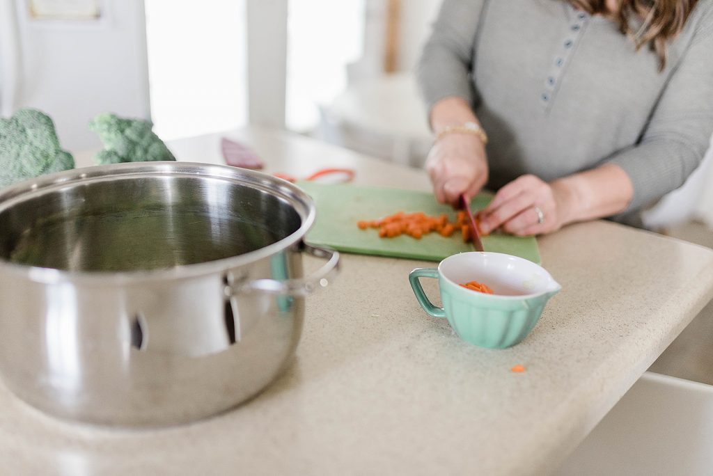 Photo of Andie chopping carrots into bite size pieces for the soup. 