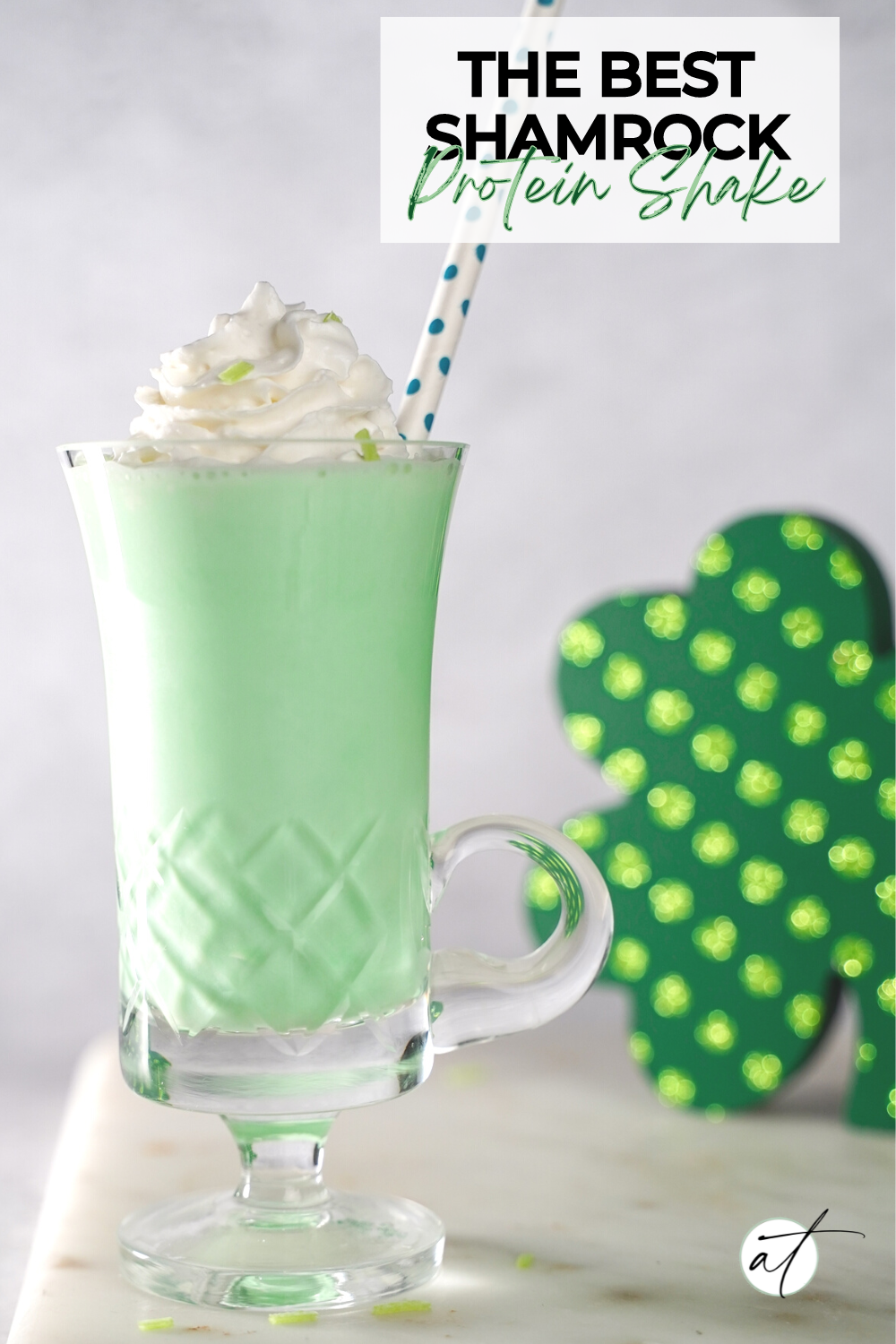 Photo of Shamrock protein shake beautifully styled with a green shamrock in the background. 