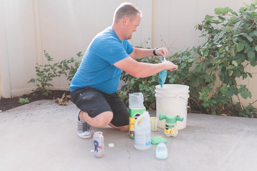 Photo of Kelly mixing up the ingredient for the plant food in his bucket. 