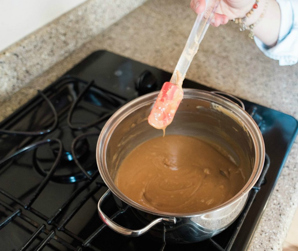 Photo melted peanut butter and honey. Photo of large pot with the ingredients over the stove. 