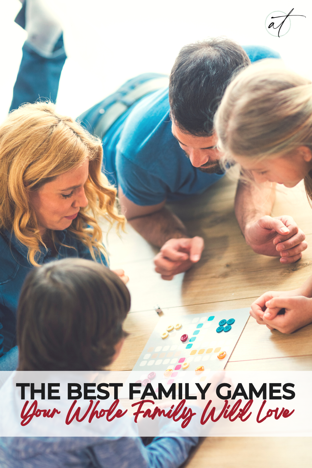 Family of four laying on the ground playing a family game and having a great time